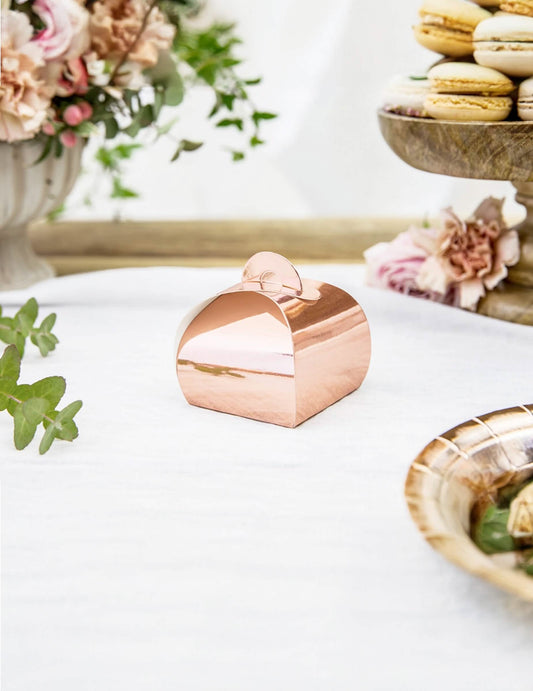 Mise en situation dans un décor de fête de la boîte en carton à dragées rose gold métallisée