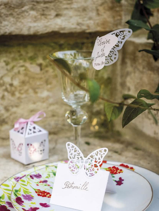 Mise en scène sur une table de fête du marque-places papillons dentelles