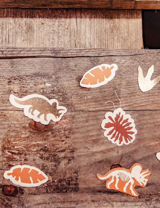 Gros plan sur les motifs variés des confettis Dinosaures Joyeux Anniversaire