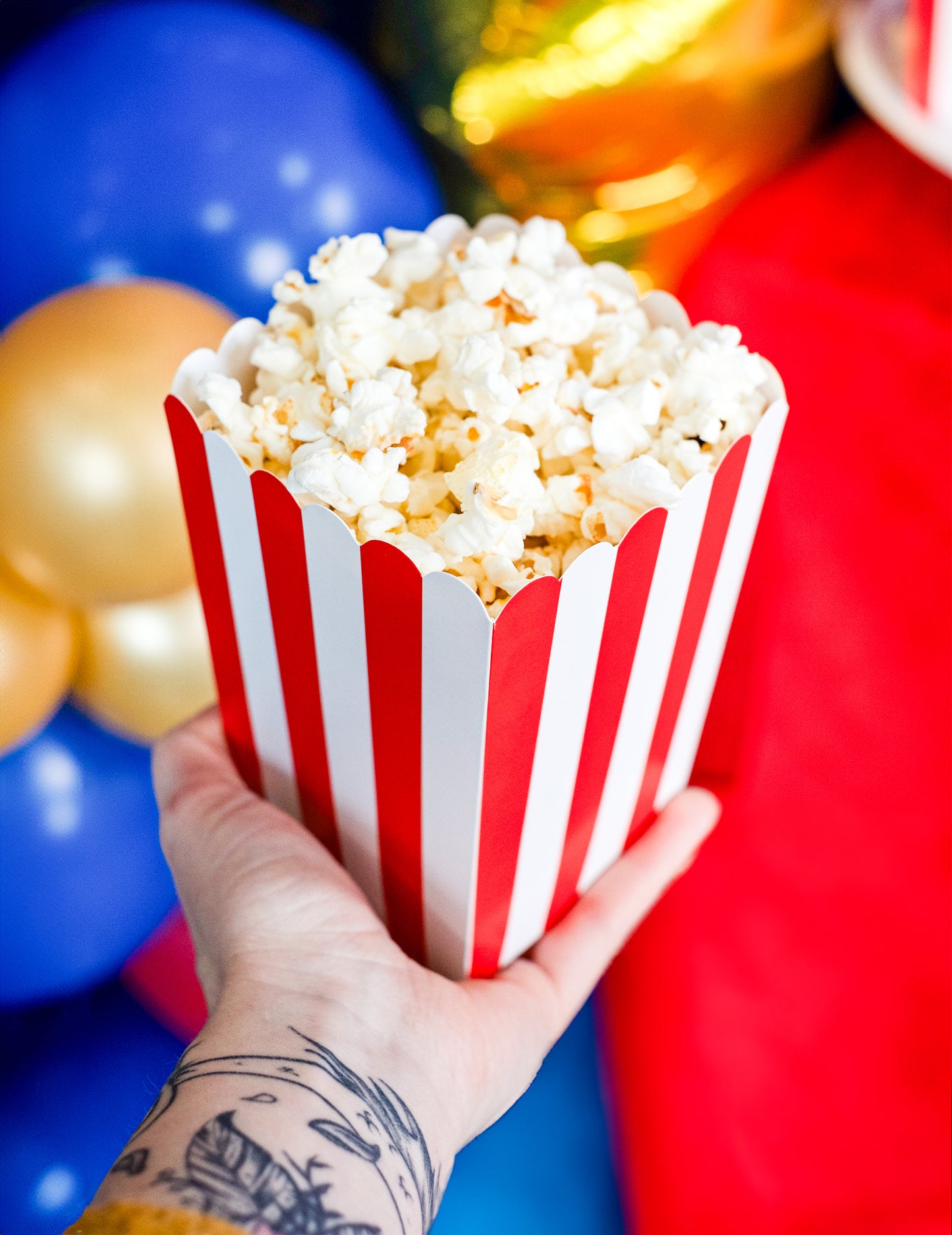Boîte remplie tenue en main des boîtes à popcorn en carton pour fête rouges et blanches à rayures