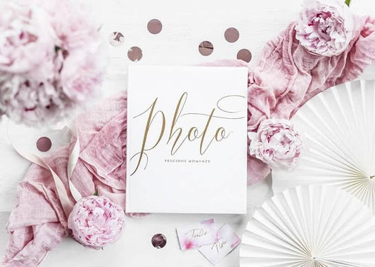 Mise en scène avec décor floral de l'album photo mariage blanc et doré