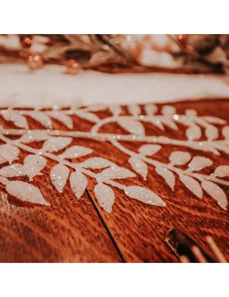 Gros plan sur les feuilles pailletées de la branche de feuillage à paillettes pour décoration blanche