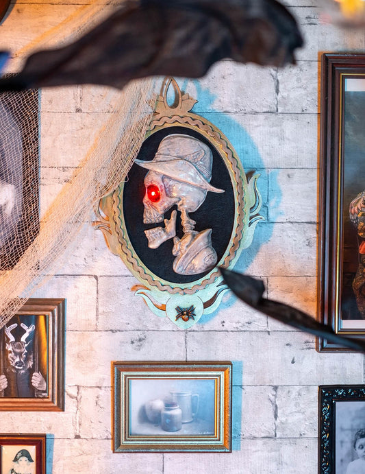 Détail de l'œil lumineux rouge du cadre portrait gentilhomme squelette