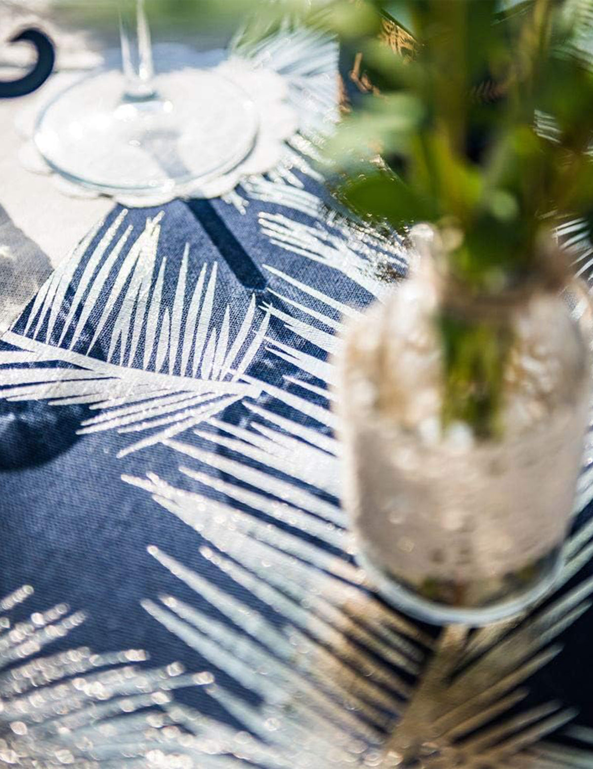 Gros plan sur les motifs dorés du chemin de table chic en lin fougères