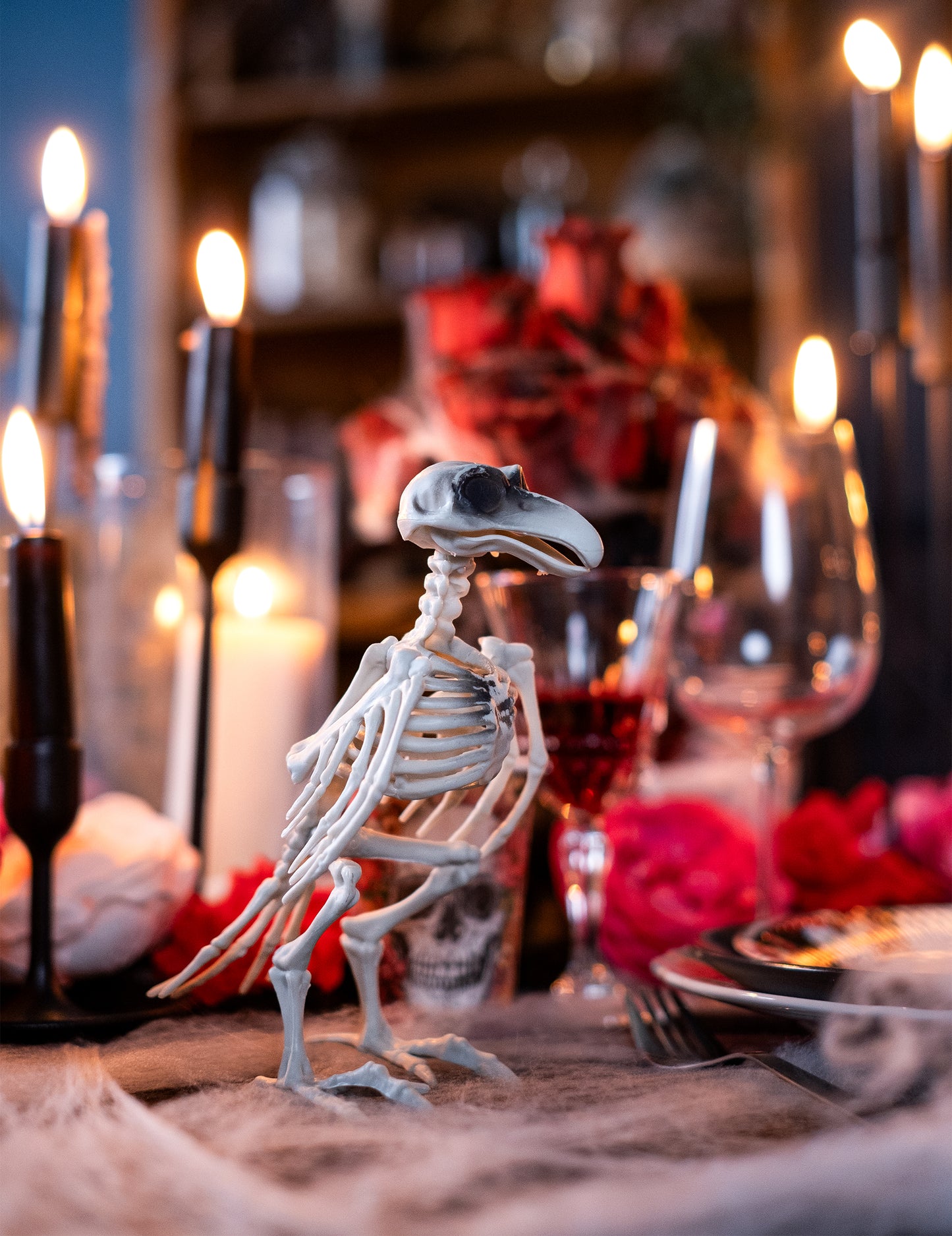 Mise en scène avec bougies de la décoration squelette de corbeau pour Halloween