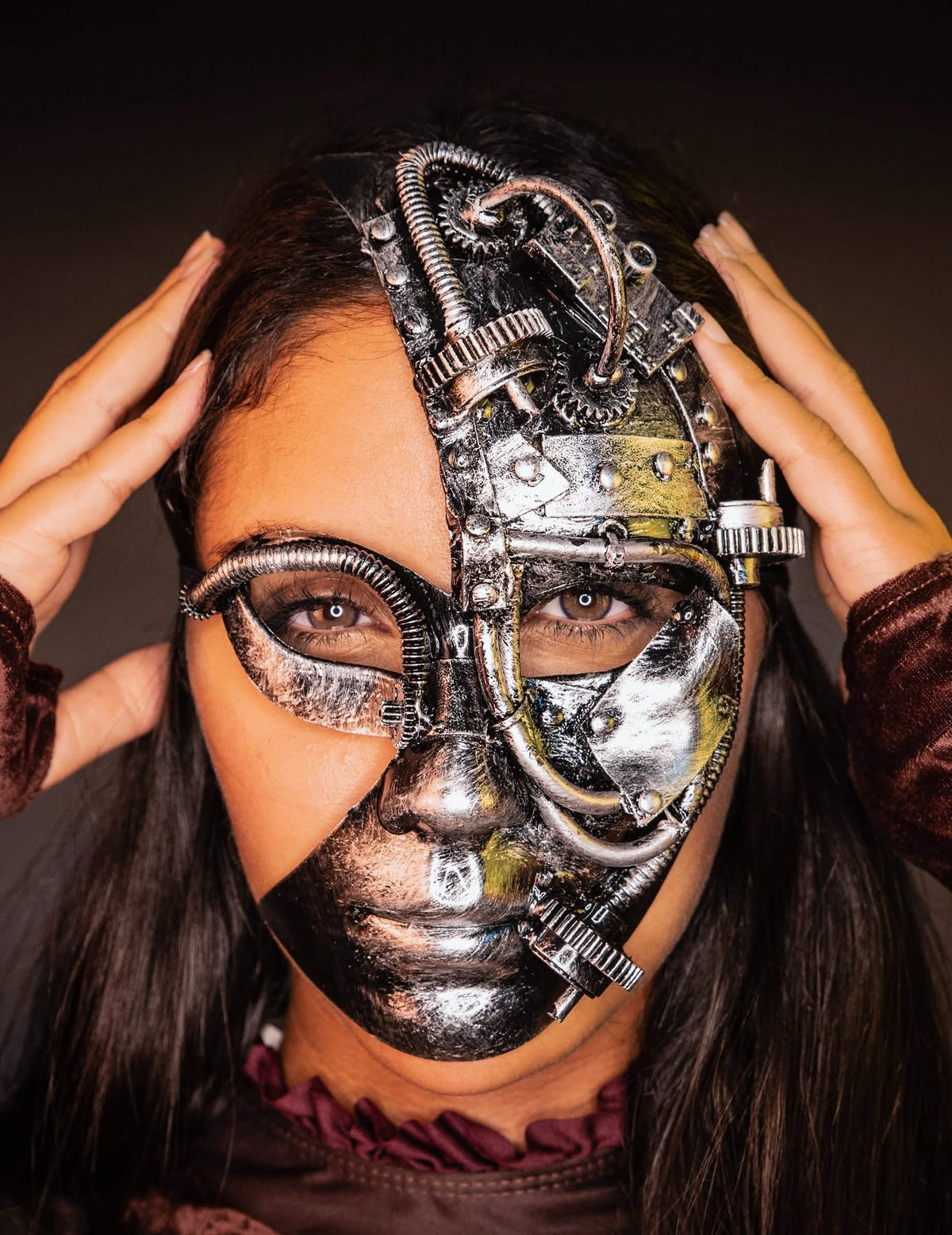 Pogled sprijeda s rukama na sljepoočnicama polumaske robot steampunk