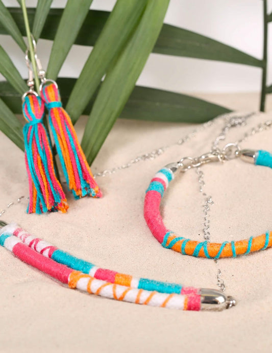 Détail des boucles d'oreilles à pompons et du bracelet du kit création de bijoux parure