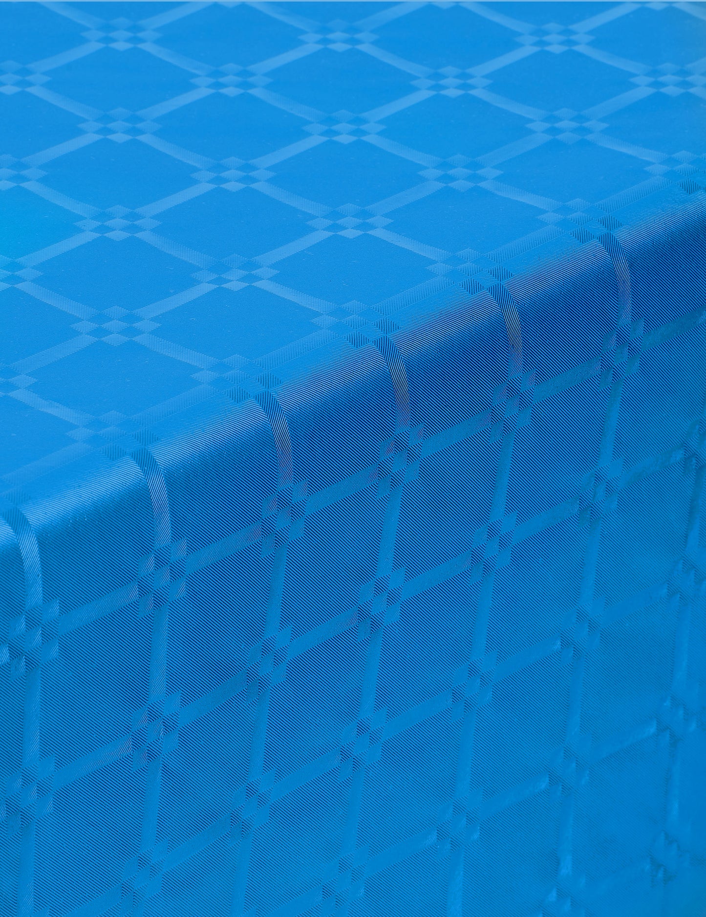 Gros plan sur le relief de la nappe en rouleau papier damassé bleu avec motifs de frises grecques