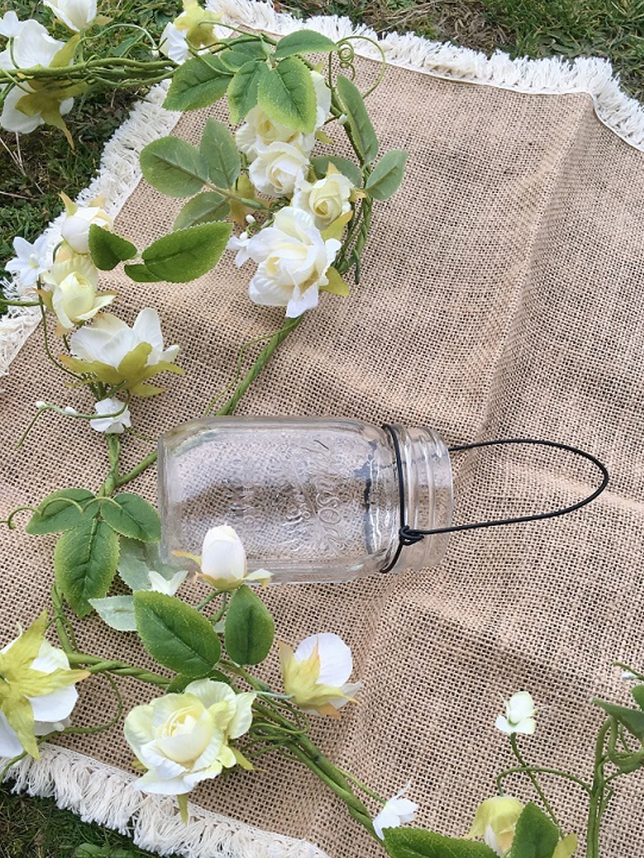 Mise en scène sur toile de jute du vase en verre mason jar