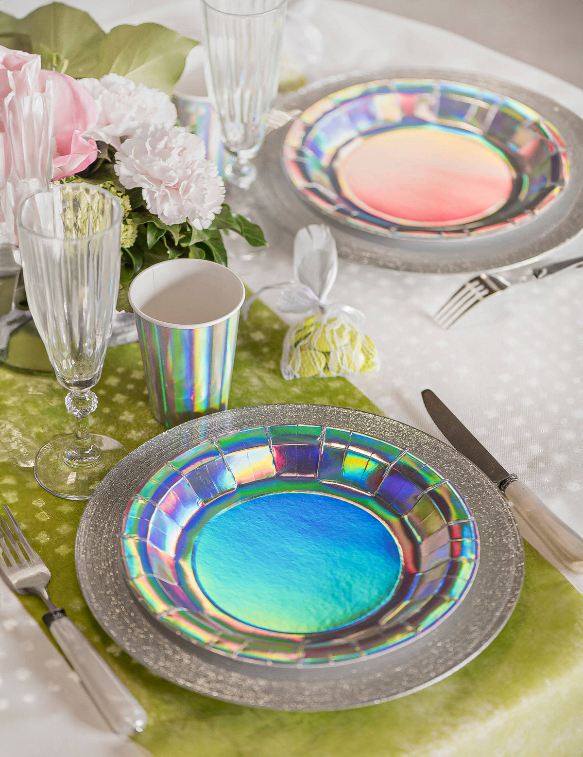 Mise en situation sur une table des assiettes en carton iridescentes pour fête