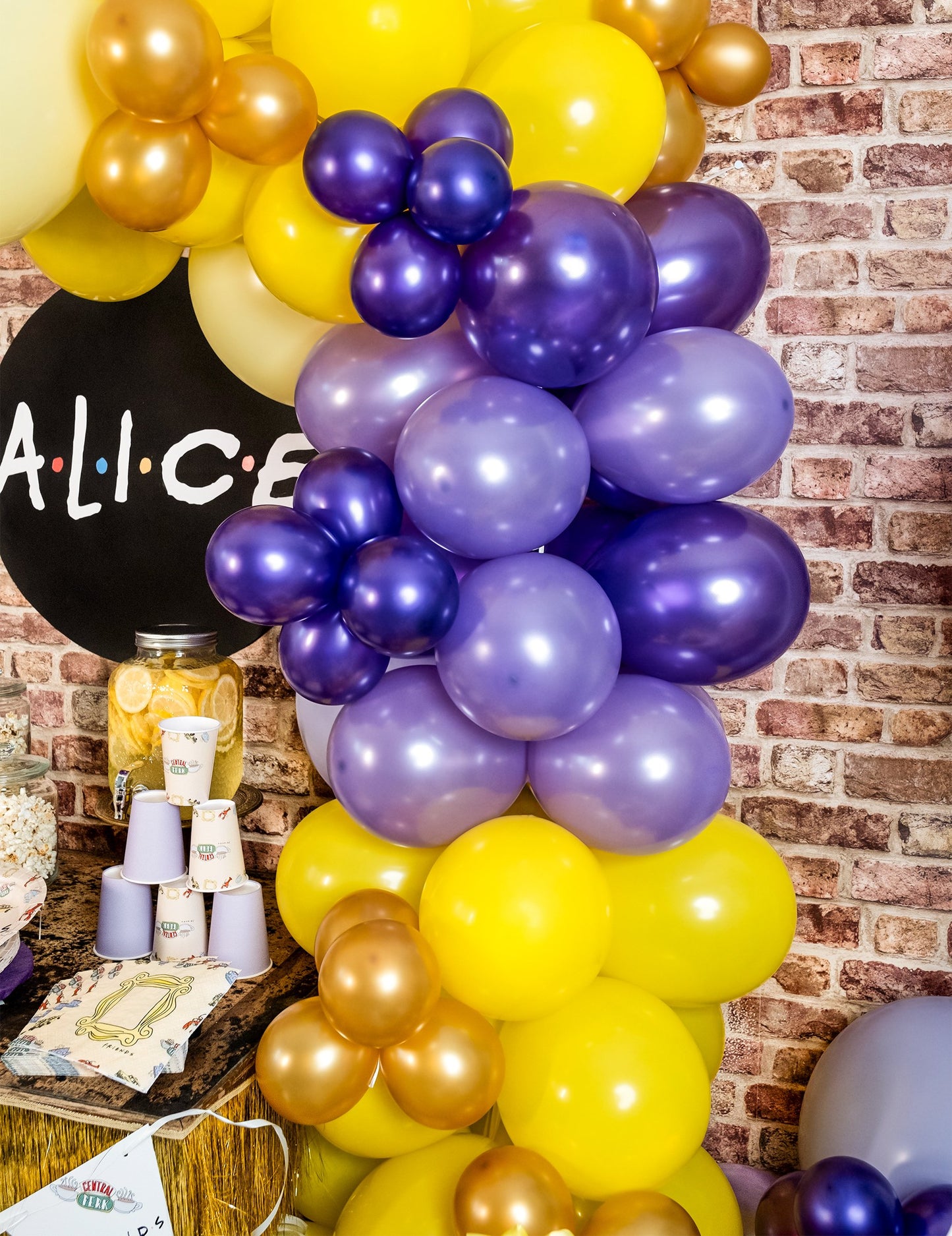 Postavljanje dekoracije za zabavu s ljubičastim metalnim balonima