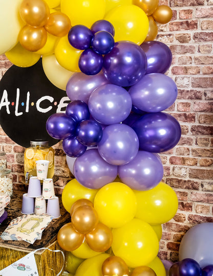 Postavljanje dekoracije za zabavu s ljubičastim metalnim balonima