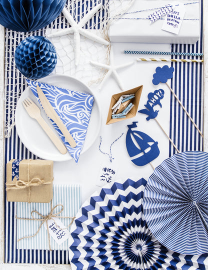 Mise en situation sur une table de fête des 3 rosaces en papier bleu marine à motifs