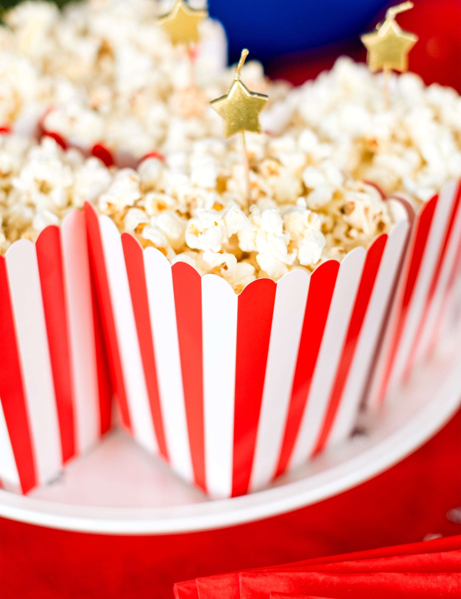 Gros plan sur les boîtes remplies des boîtes à popcorn en carton pour fête rouges et blanches à rayures