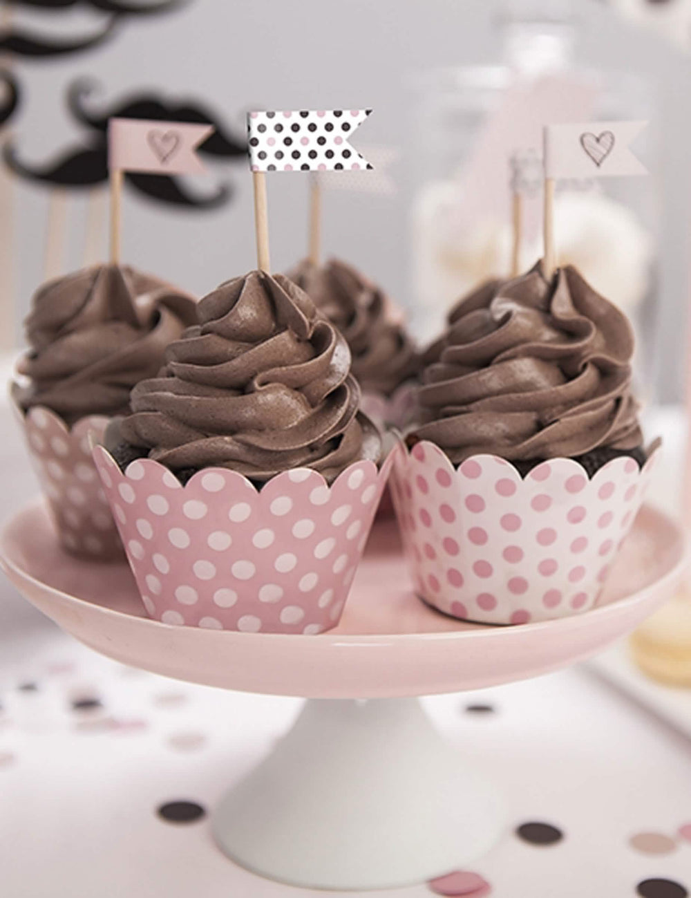 Postavljanje cupcake omotača s roza točkicama u puderasto ružičastoj boji od kartona