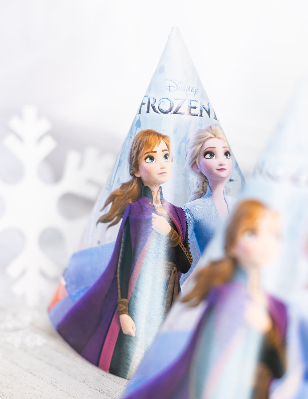 Gros plan sur les personnages Anna et Elsa du chapeau de fête en carton La Reine des Neiges 2