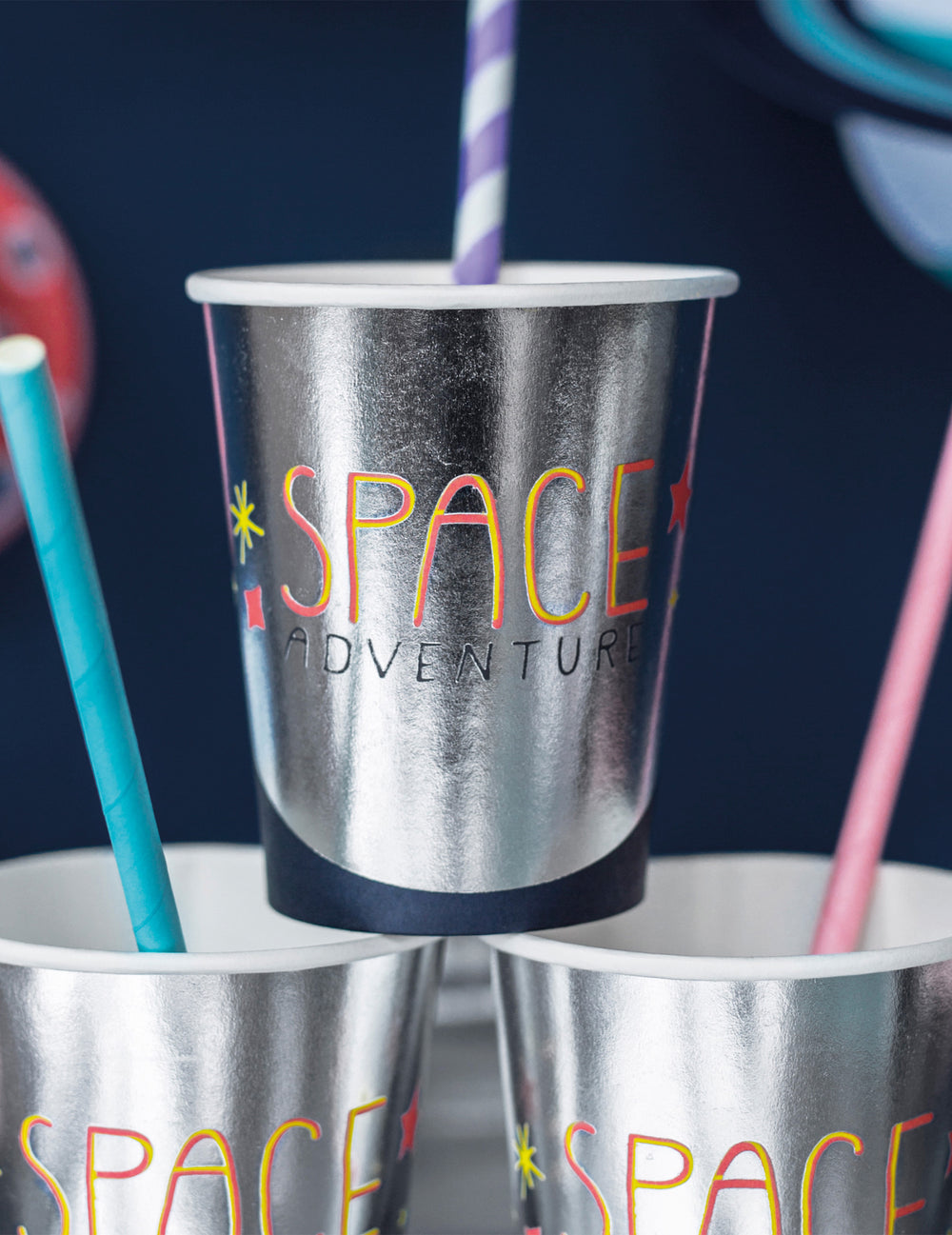 Gros plan sur le motif et les pailles des gobelets en carton space adventure