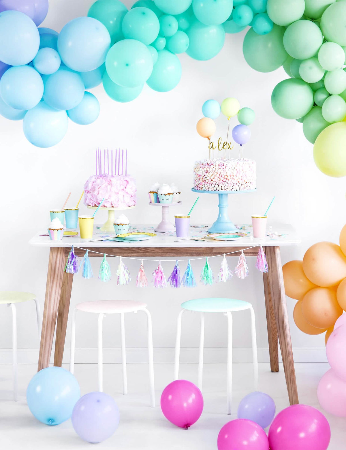 Scenografija s lukom od balona i omotima za cupcake s pastelnim jednorozima