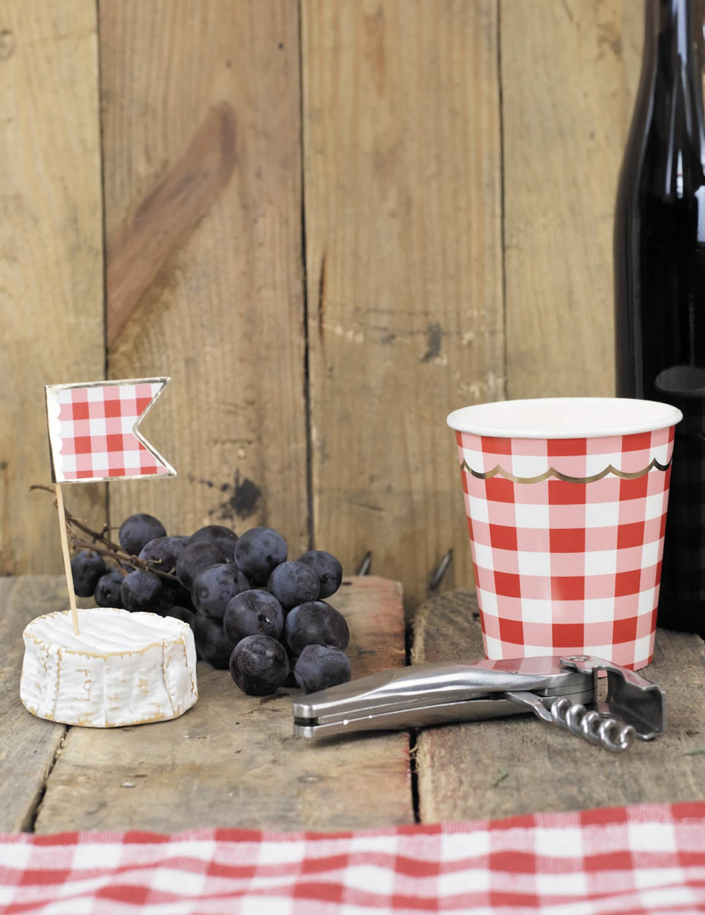 Mise en situation champêtre du gobelet en carton festonné vichy pour fête rouge et blanc