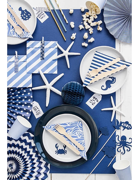 Mise en situation sur une table de fête des décorations pour gâteau sur pique motifs mer bleu marin