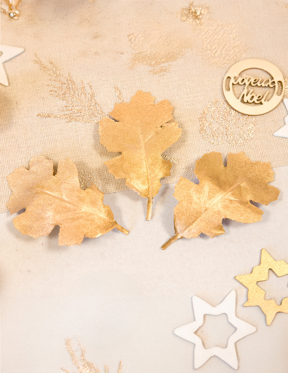 Mise en situation de trois feuilles de chêne en tissu métallisé pour décoration dorées