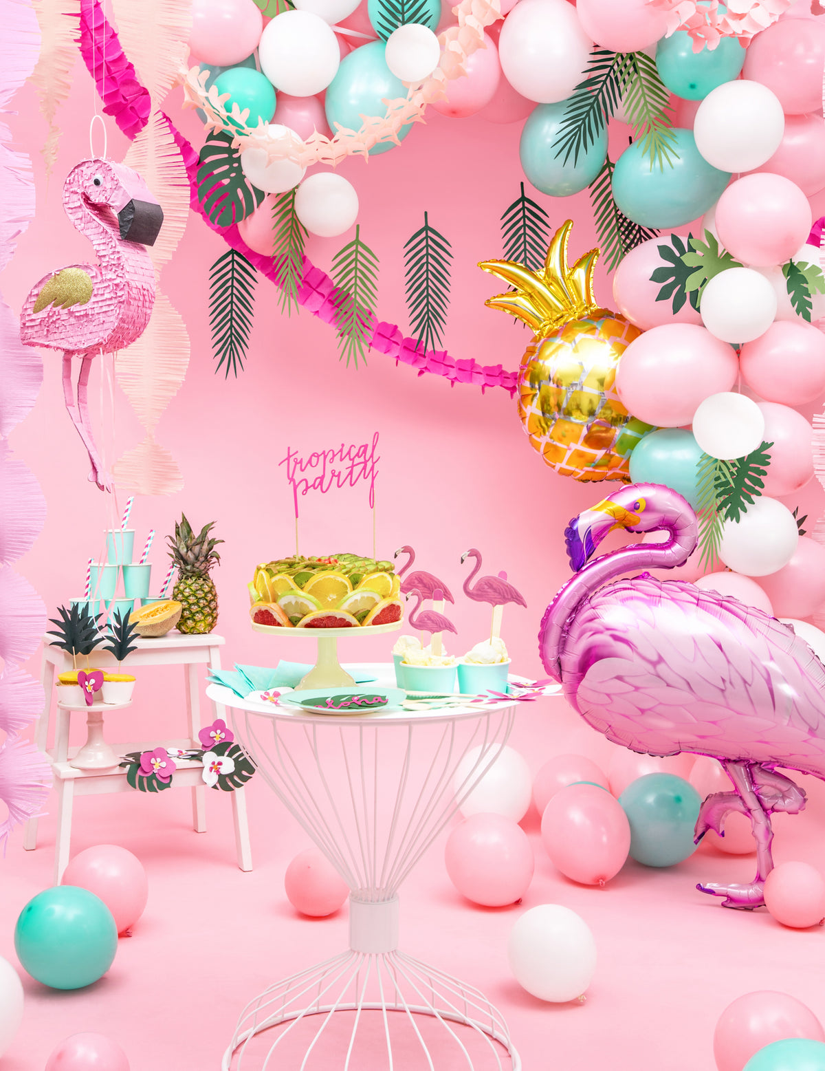 Mise en scène du ballon aluminium ananas doré dans un décor de fête tropicale