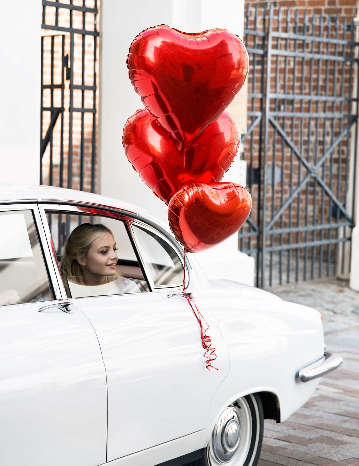 Prikaz na automobilu s crvenim metalik aluminijskim balonom u obliku srca za zabavu