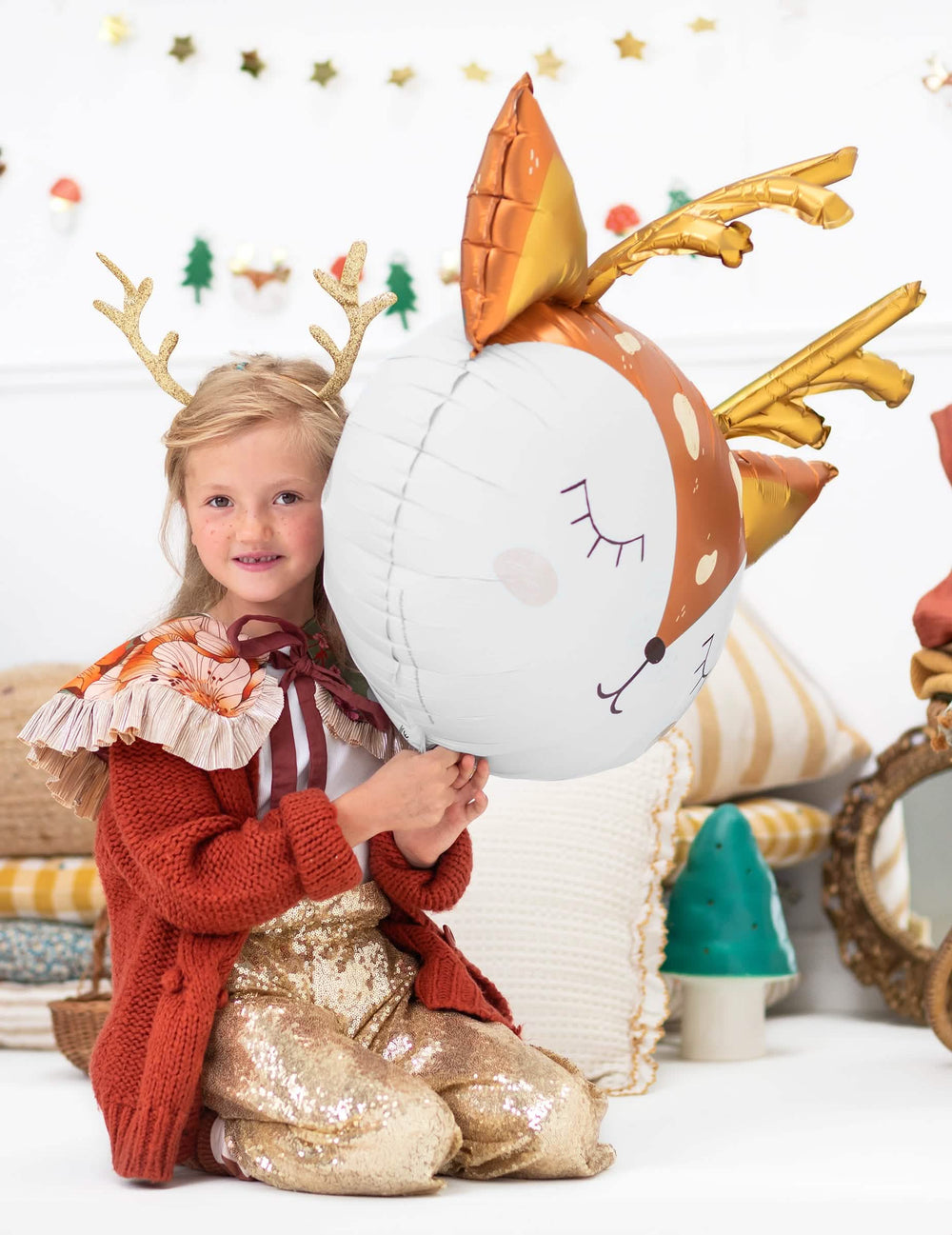 dijete koje drži veliki aluminijski balon u obliku jelenove glave