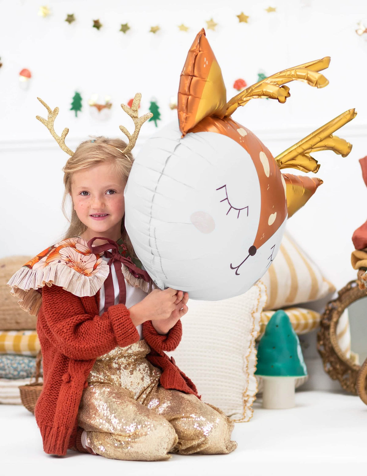 dijete koje drži veliki aluminijski balon u obliku jelenove glave