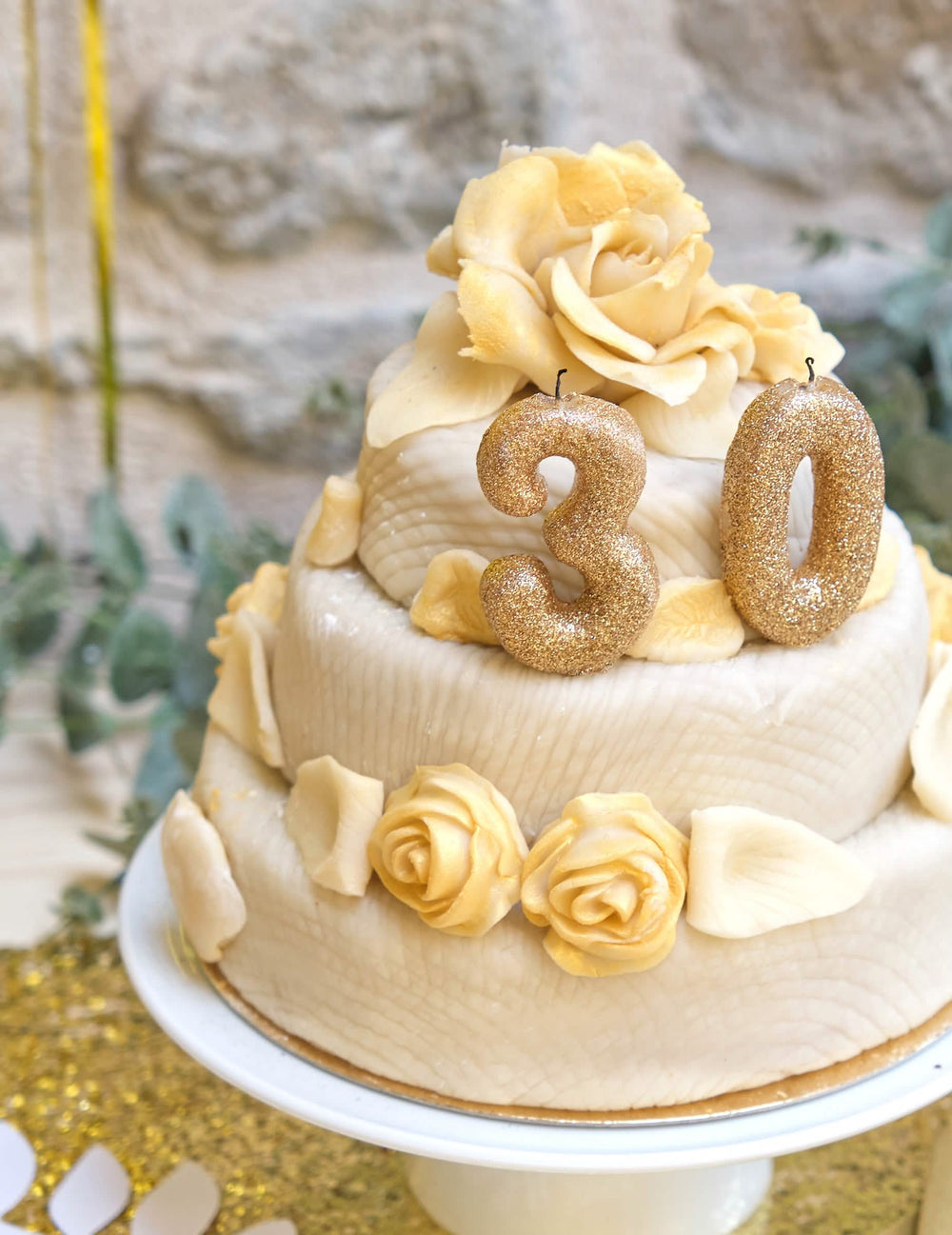 Krupni plan torte sa svjećicom broj 0 za zlatna rođendan s glitterom