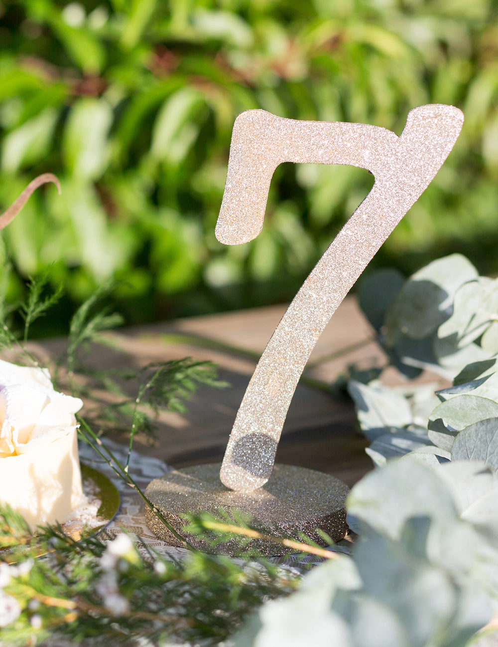 Gros plan du centre de table chiffre 7 bois pailleté champagne sur socle