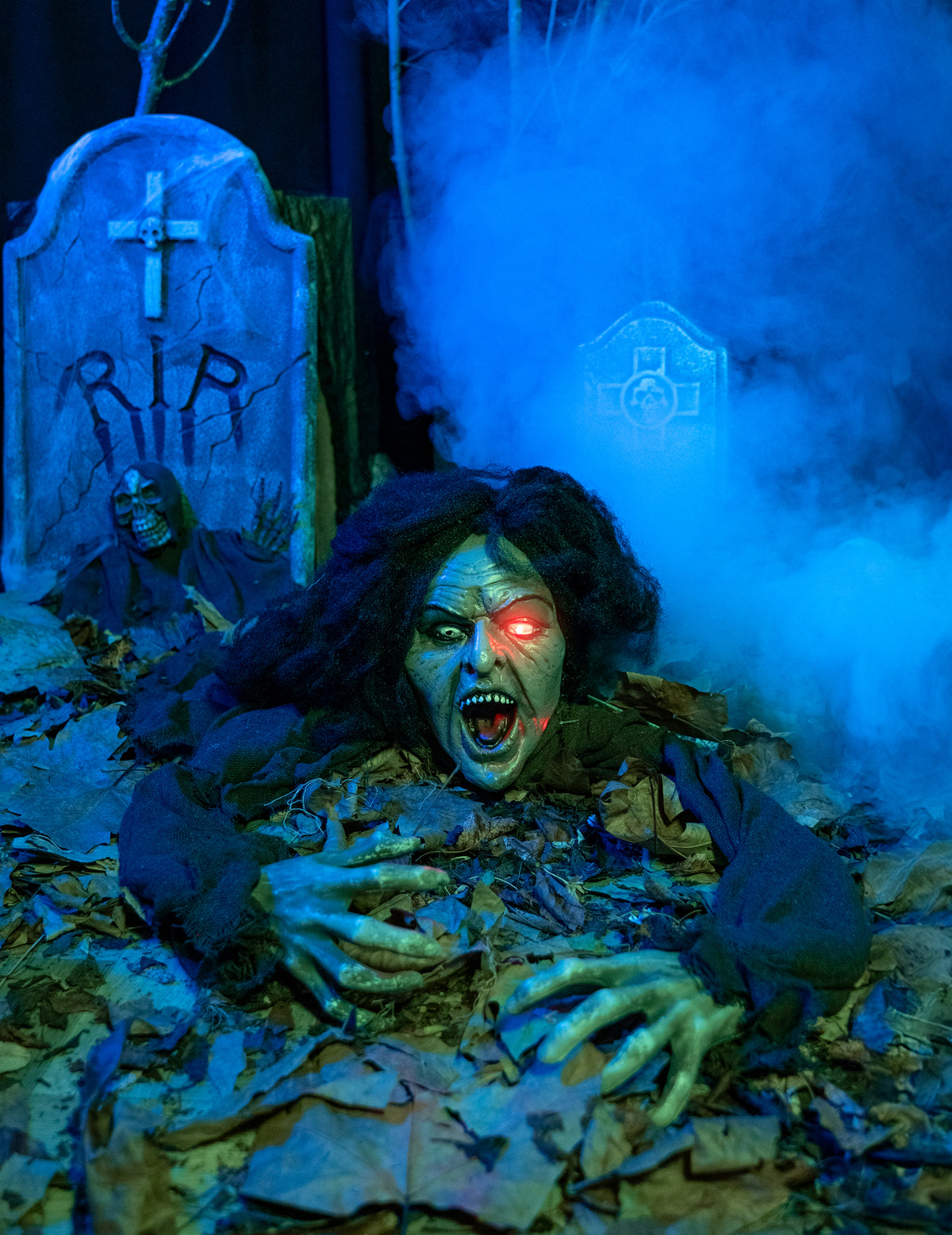 Mise en scène dans un cimetière de la décoration sorcière sonore et lumineuse pour Halloween