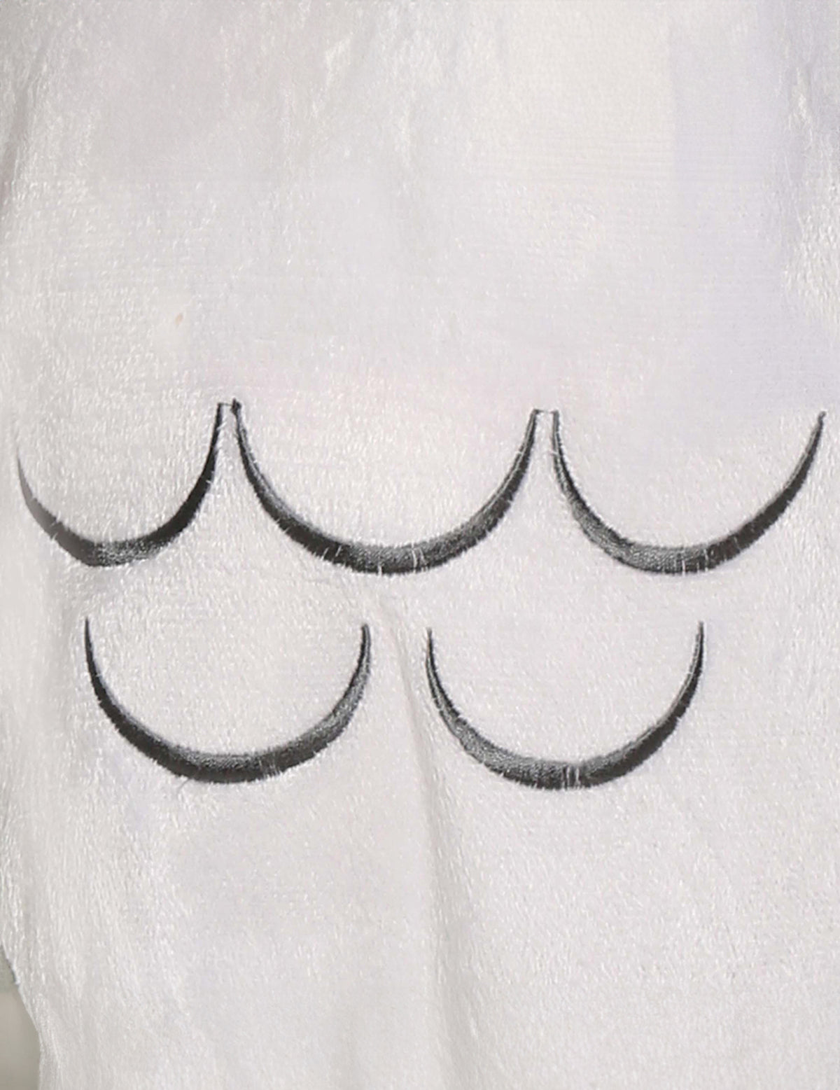 Gros plan sur les motifs de plumes du déguisement chouette magique pour bébé