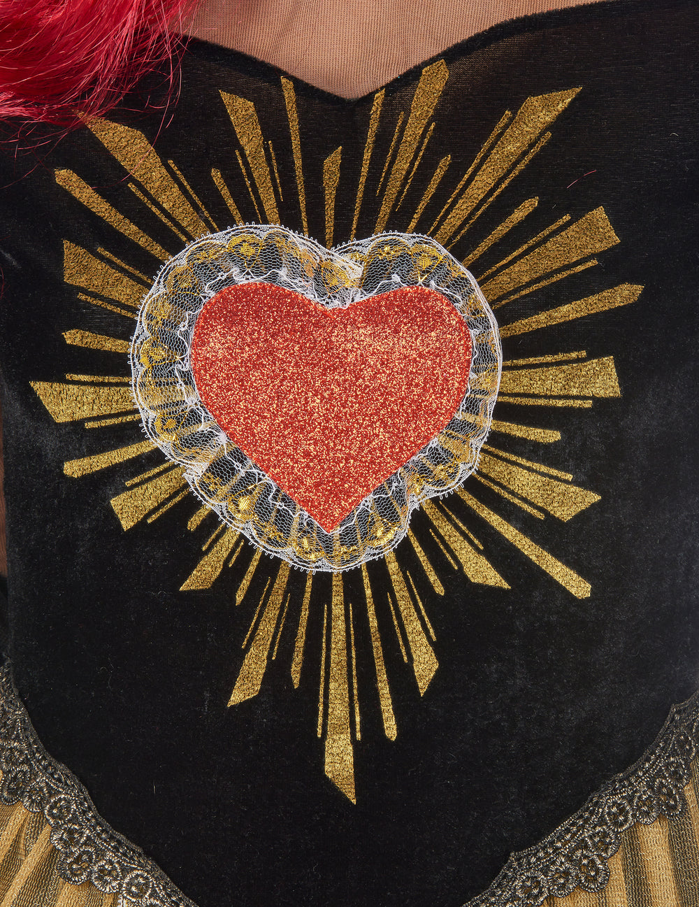 Gros plan sur le motif coeur pailleté avec rayons dorés du déguisement reine du Dia de los muertos