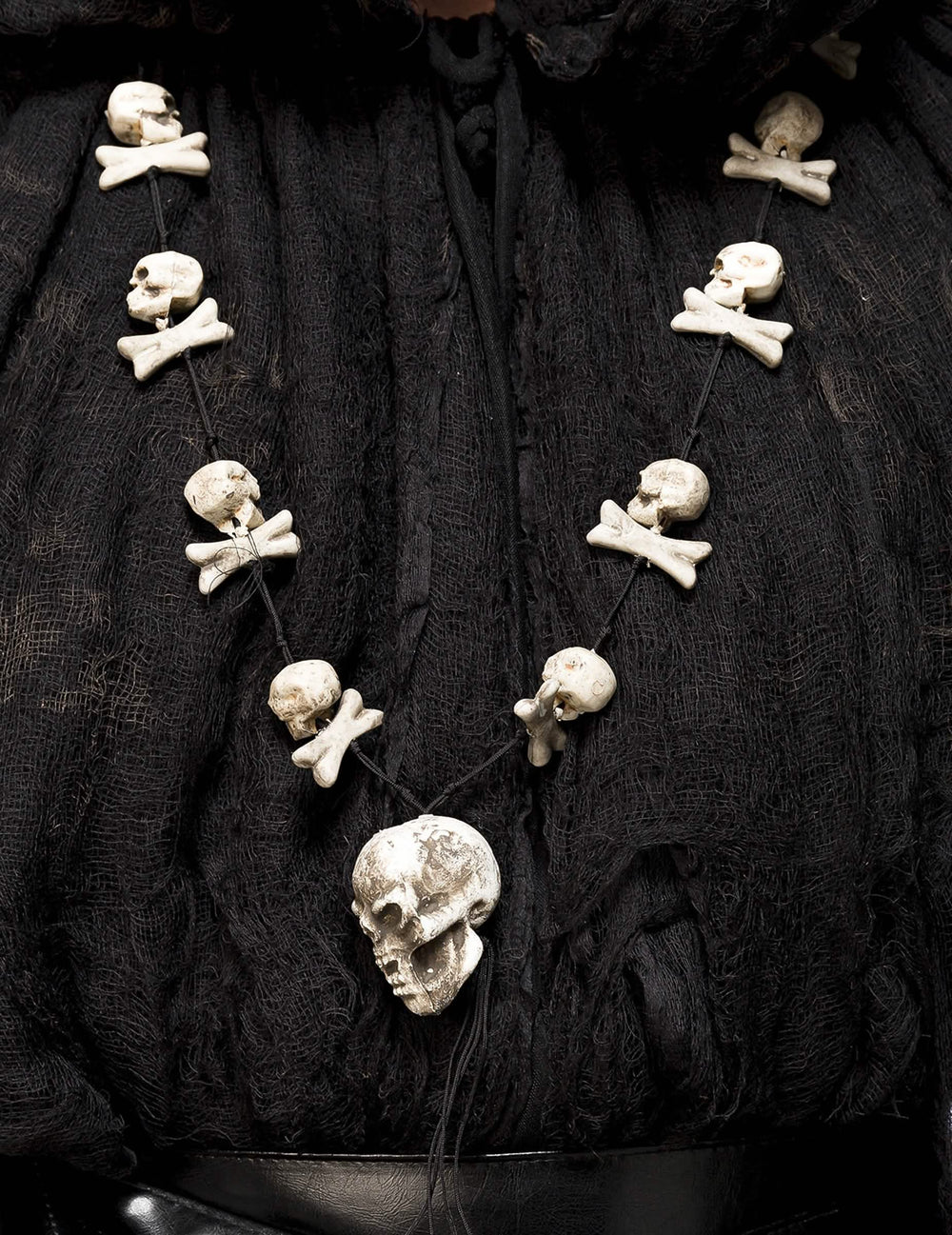 Détail du collier avec têtes de mort et os du déguisement sorcier occulte avec masque luxe