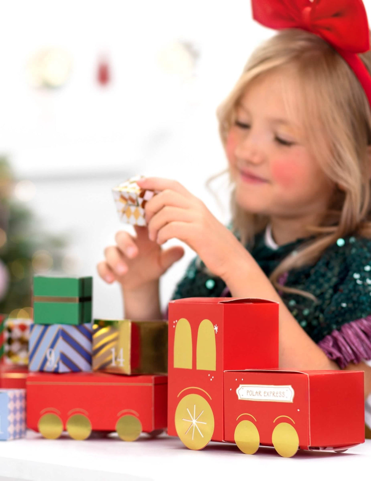 dijete koje rukuje kutijom DIY adventskog kalendara božićnog vlaka