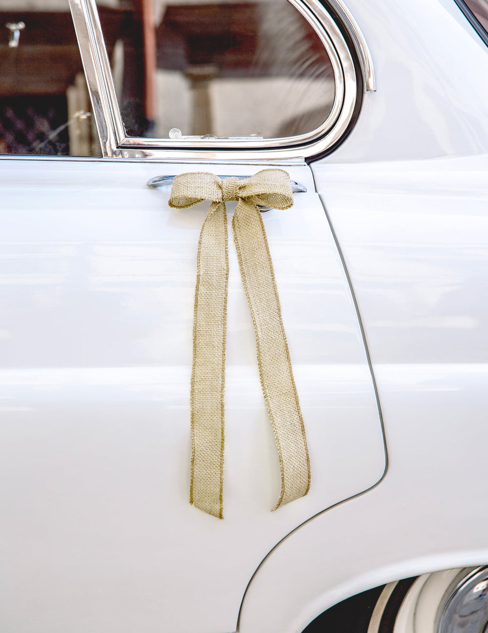Nœud en jute sur une poignée de porte du kit décoration de voiture mariage bohème