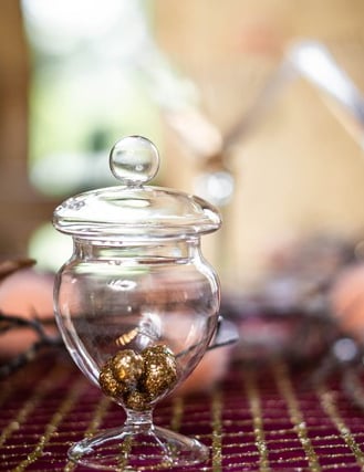 Gros plan sur les billes dorées à l'intérieur de la mini bonbonnière confiseur sur pied en verre