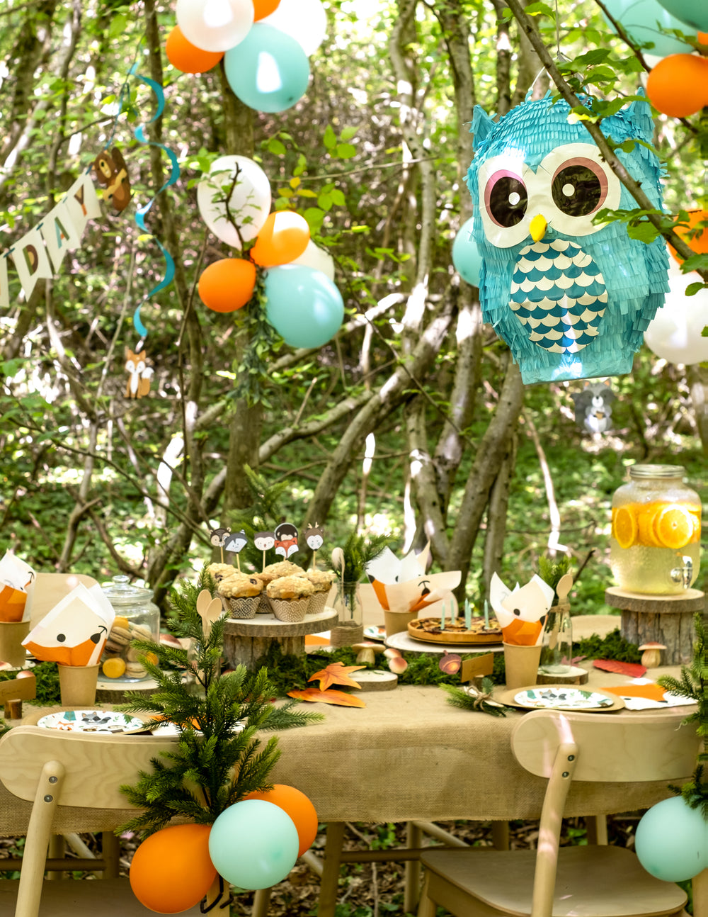 Mise en situation de la pinata hibou dans un décor de fête en forêt