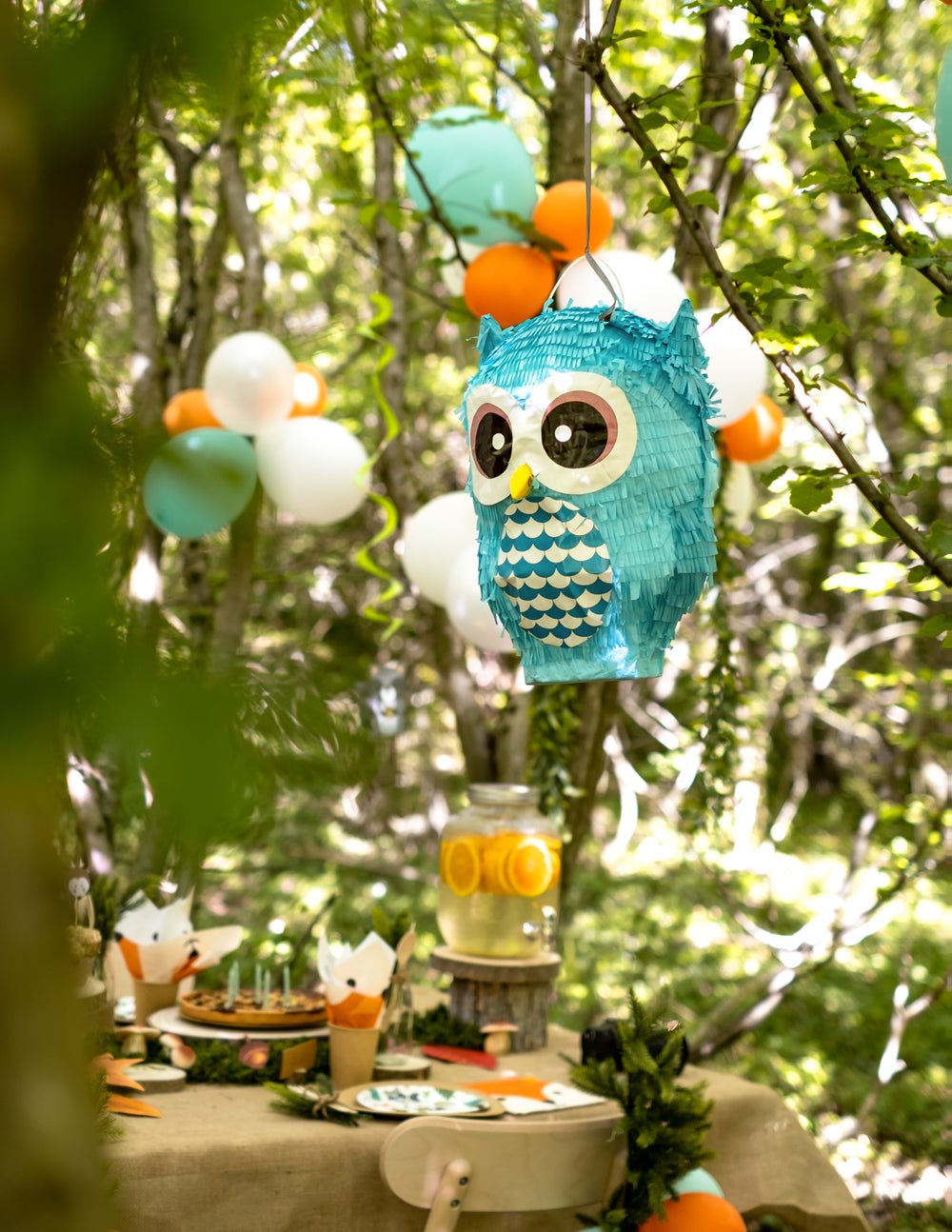Mise en scène de la pinata hibou suspendue à une branche d'arbre