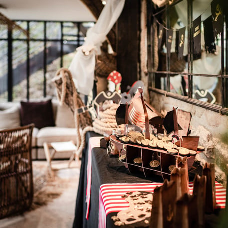 Mise en scène sur une table de fête du présentoir bateau pirate pour gâteaux