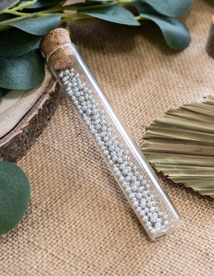 Detalj srebrnih perlica unutar staklene epruvete za zabavu