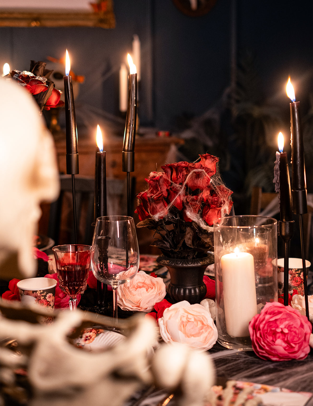 Mise en situation sur une table d'Halloween du vase gothique avec roses et toiles d'araignée